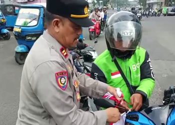 Kanit Binmas Polsek Tambora Pimpin Pembagian Bendera Merah Putih kepada Warga dan Pengguna Jalan